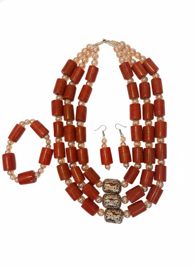 Close-up of West African coral bead necklace, bracelet, and earrings inspired by ancestral traditions