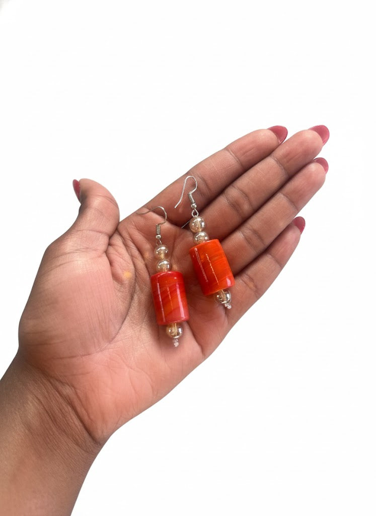 Close‑up West African coral bead earrings for weddings and cultural celebrations